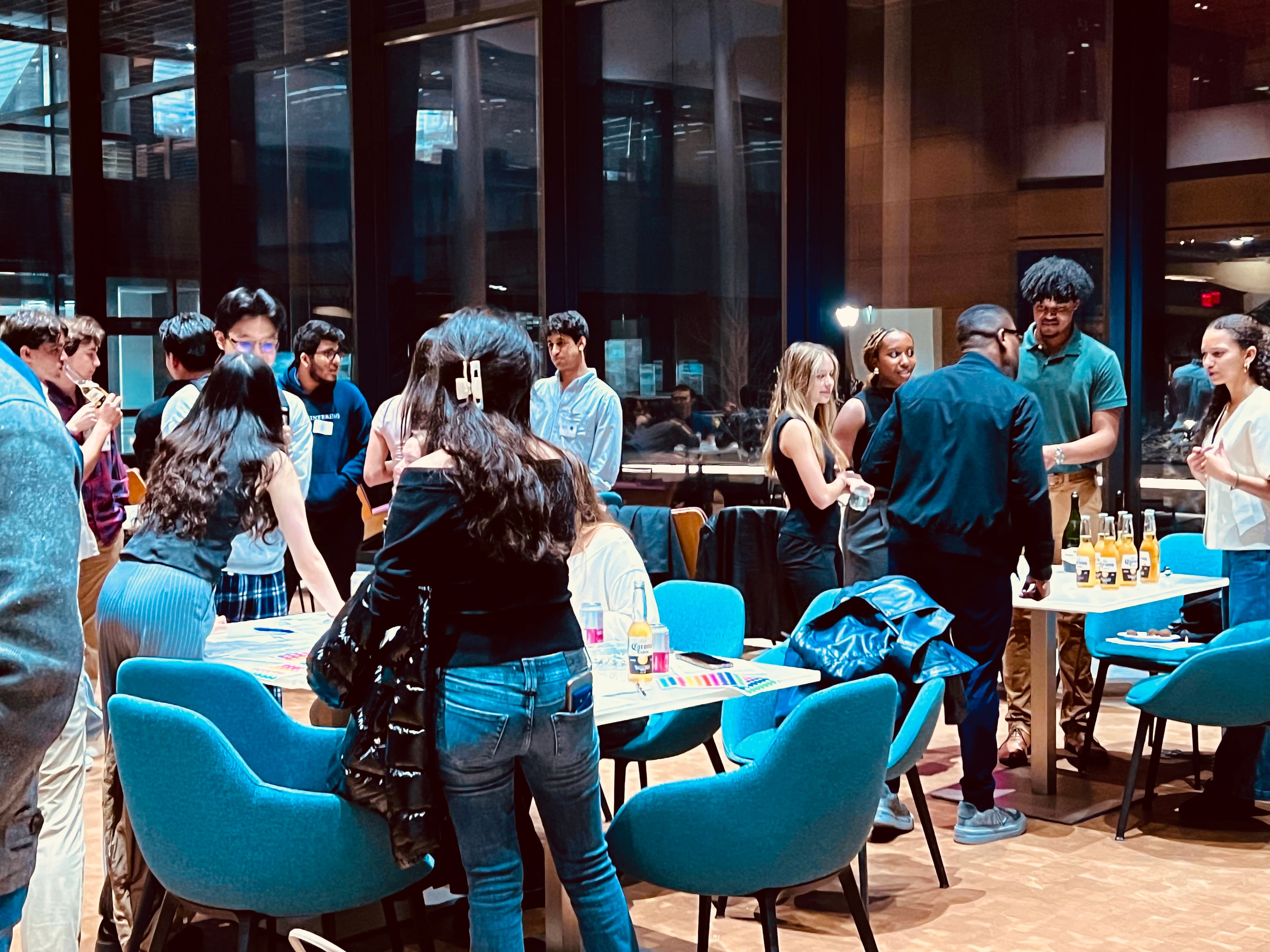 Event photo: attendees mingling around tables set with drinks